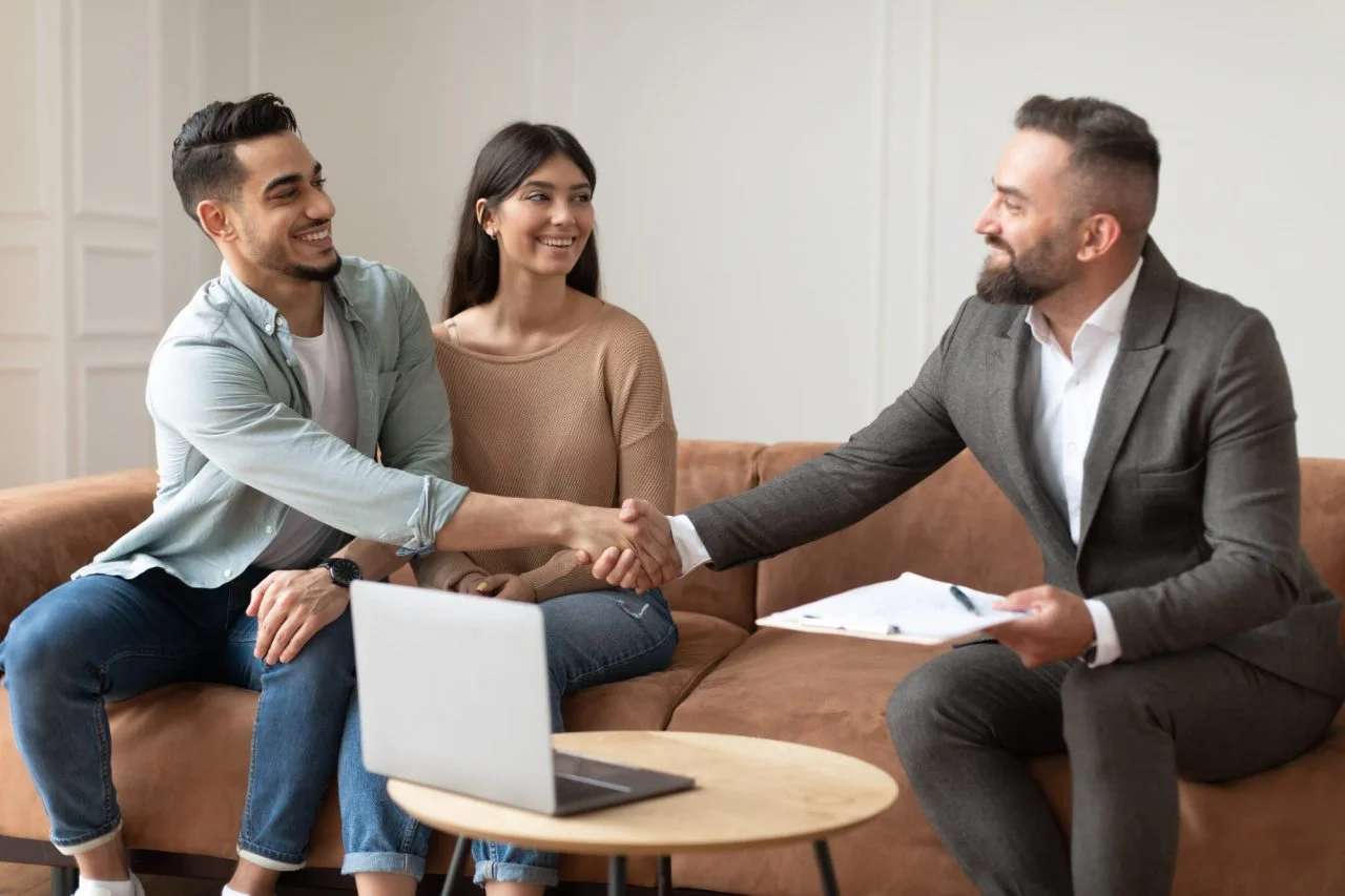 millennial-couple-buying-new-apartment-shaking-hands-with-realtor-e1695129370216 millennial-couple-buying-new-apartment-shaking-hands-with-realtor-e1695129370216